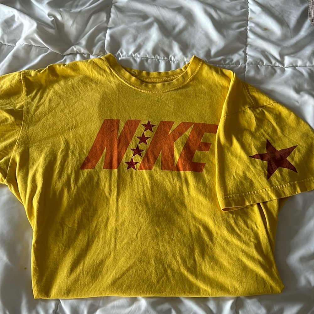 Yellow Nike T-shirt with a red star on the right shoulder.